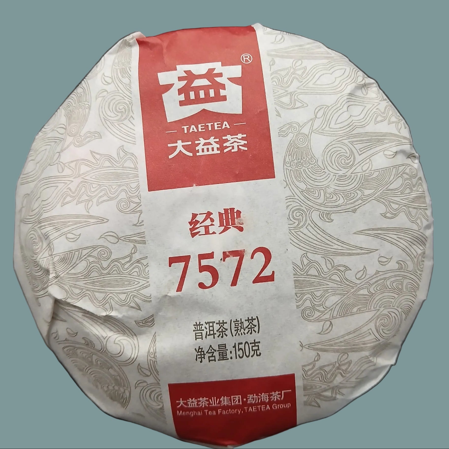Round tea product with red label featuring white text and patterns on a dark background