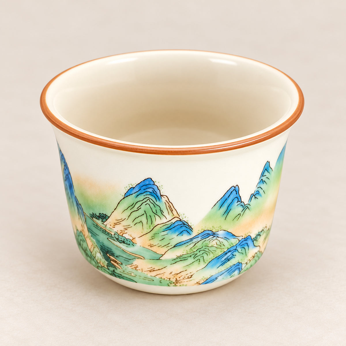 Single Qianli Jiangshan tea cup showing its cream interior and mountain decoration